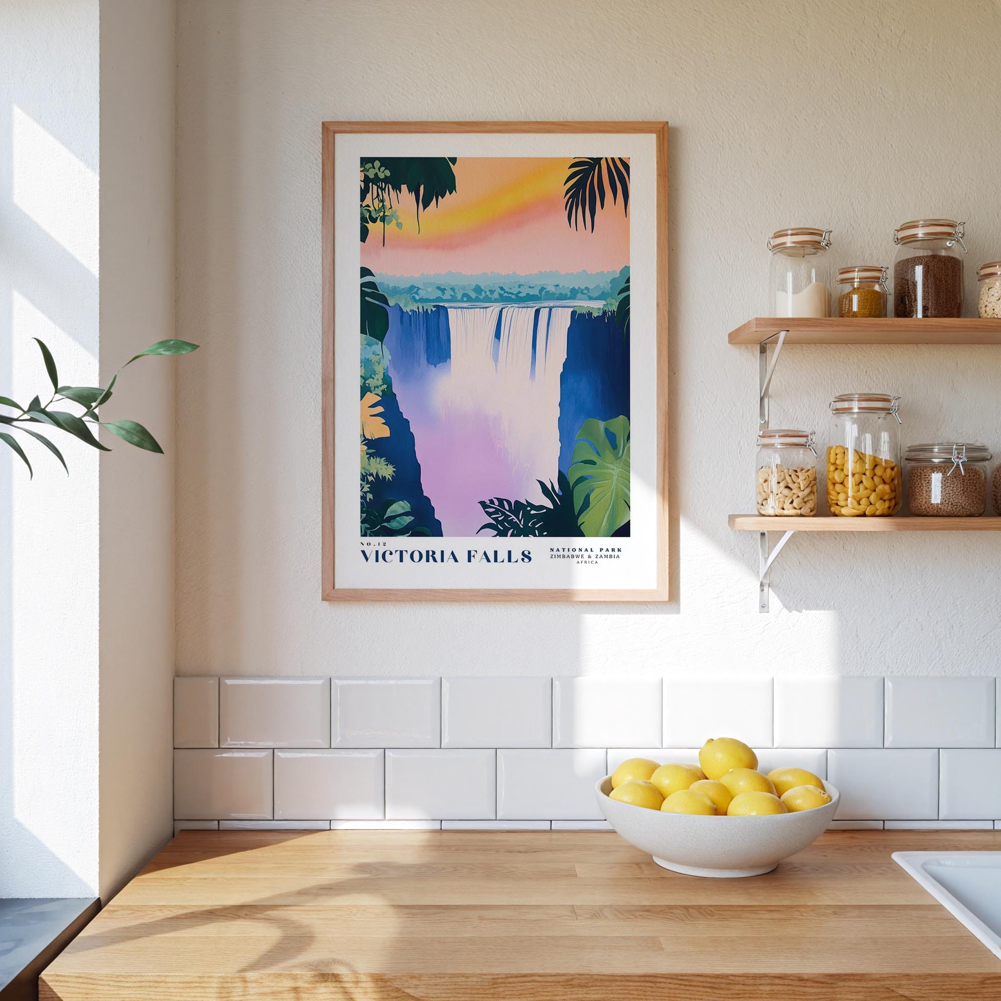a kitchen counter with a bowl of lemons, a framed poster of Victoria Falls, and various jars and containers on a shelf.