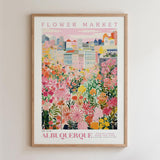 The image is a framed poster depicting a vibrant and colorful cityscape with a variety of flowers and plants in the foreground.