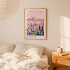 a bedroom scene with a framed poster of a cityscape of Wisconsin hanging on the wall above a bed with striped pillows.