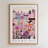 The image is a framed poster depicting a cityscape with a flower market in the background.