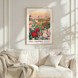 a framed poster of a cityscape with a garden of flowers in the foreground, hanging on a wall above a white couch.