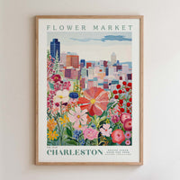 The image is a framed poster depicting a cityscape with a variety of colorful flowers in the foreground.