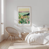 a serene bedroom scene with a large framed poster of a desert landscape hanging on the wall, featuring a desert and mountains. The room has a white color scheme, with a bed, a woven chair, and a small side table. The overall atmosphere is calm and peaceful, with the poster adding a touch of nature and color to the space.