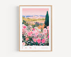 A framed poster depicting a vibrant garden filled with pink and white flowers, with a cityscape visible in the background.