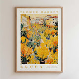 The image is a framed poster depicting a vibrant flower market scene in Lucca, Italy.