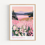 A framed poster depicting a scenic landscape with a lake, mountains, and a field of pink flowers.