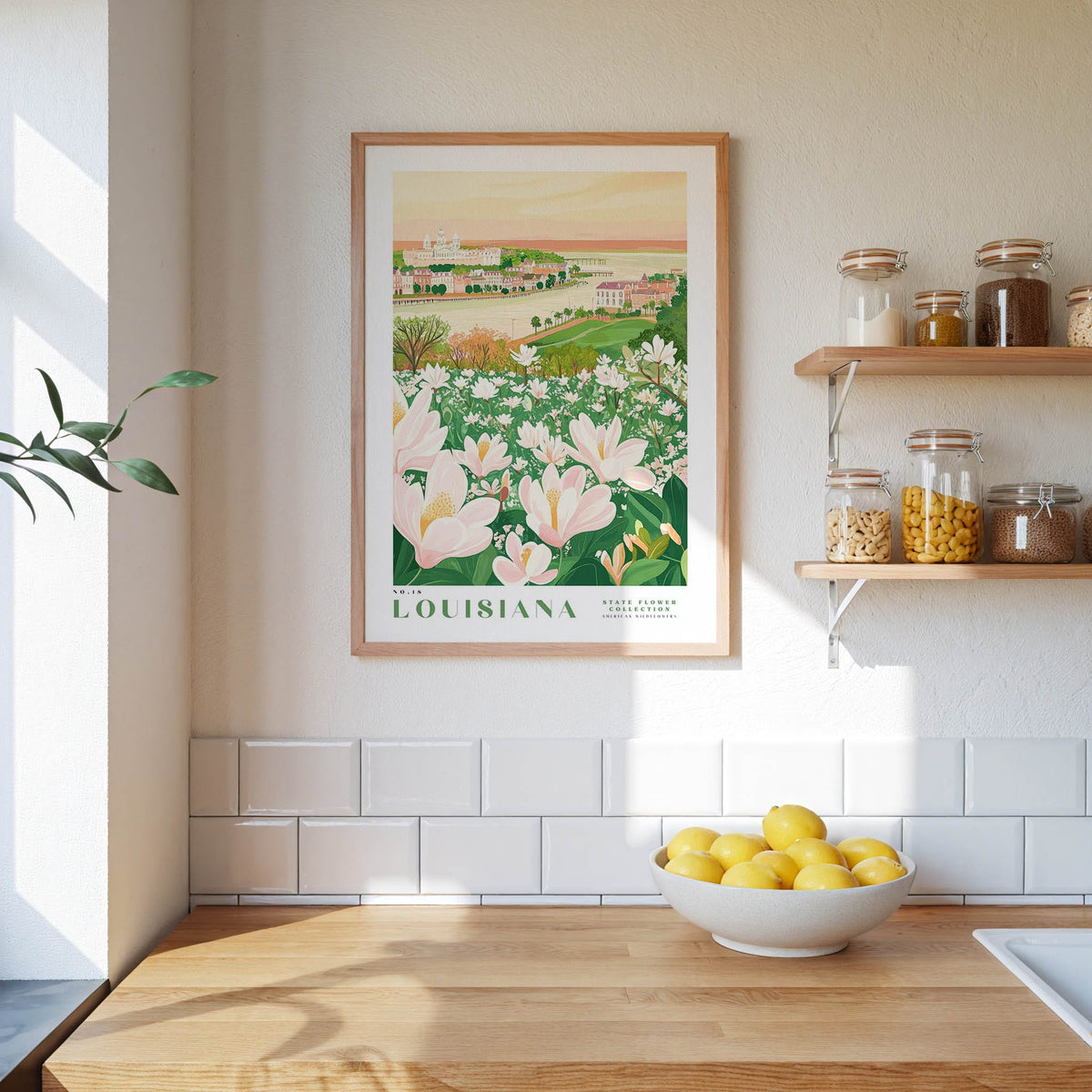 a framed poster of a field of flowers hanging on a wall above a wooden countertop with a bowl of lemons.