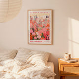 a bedroom scene with a framed poster of a cityscape and a bed with striped pillows.