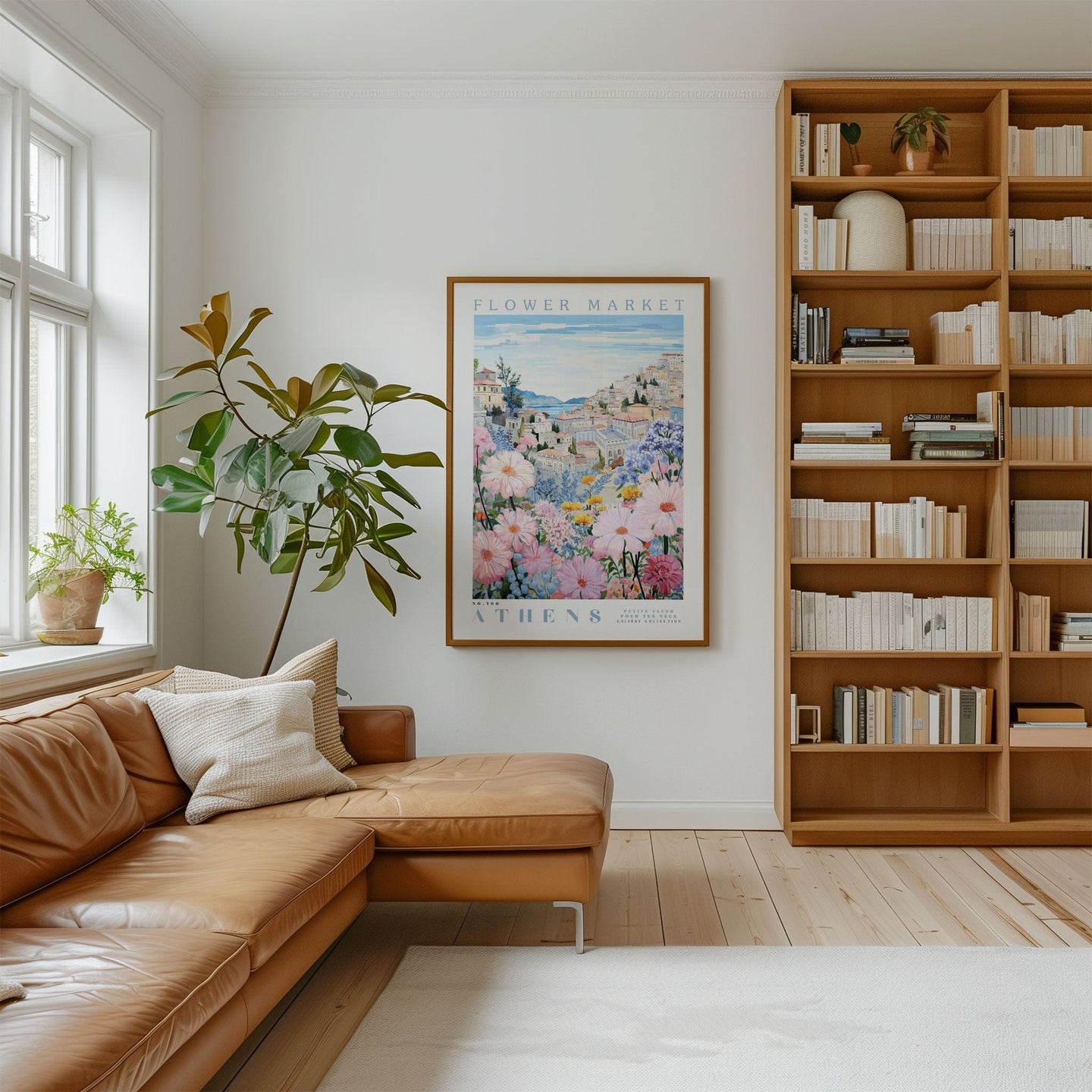 a cozy living room with a large window, a comfortable leather couch, a bookshelf filled with books, and a framed poster of a flower market in Athens hanging on the wall.