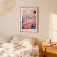 a bedroom scene with a framed poster of a cityscape and flowers hanging on the wall above a bed with striped pillows.