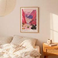 a bedroom with a bed, a nightstand, and a framed poster of a desert landscape hanging on the wall.
