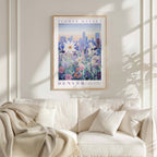 a framed poster of a cityscape with flowers hanging on a wall above a white couch with pillows.