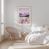 A bedroom with a large poster of a mountain landscape hanging on the wall, featuring a serene scene of mountains, trees, and a lake. The room has a white bed, a woven chair, and a wooden nightstand with a lamp.
