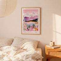 a bedroom scene with a framed poster of a mountain landscape hanging on the wall above a bed with striped pillows.