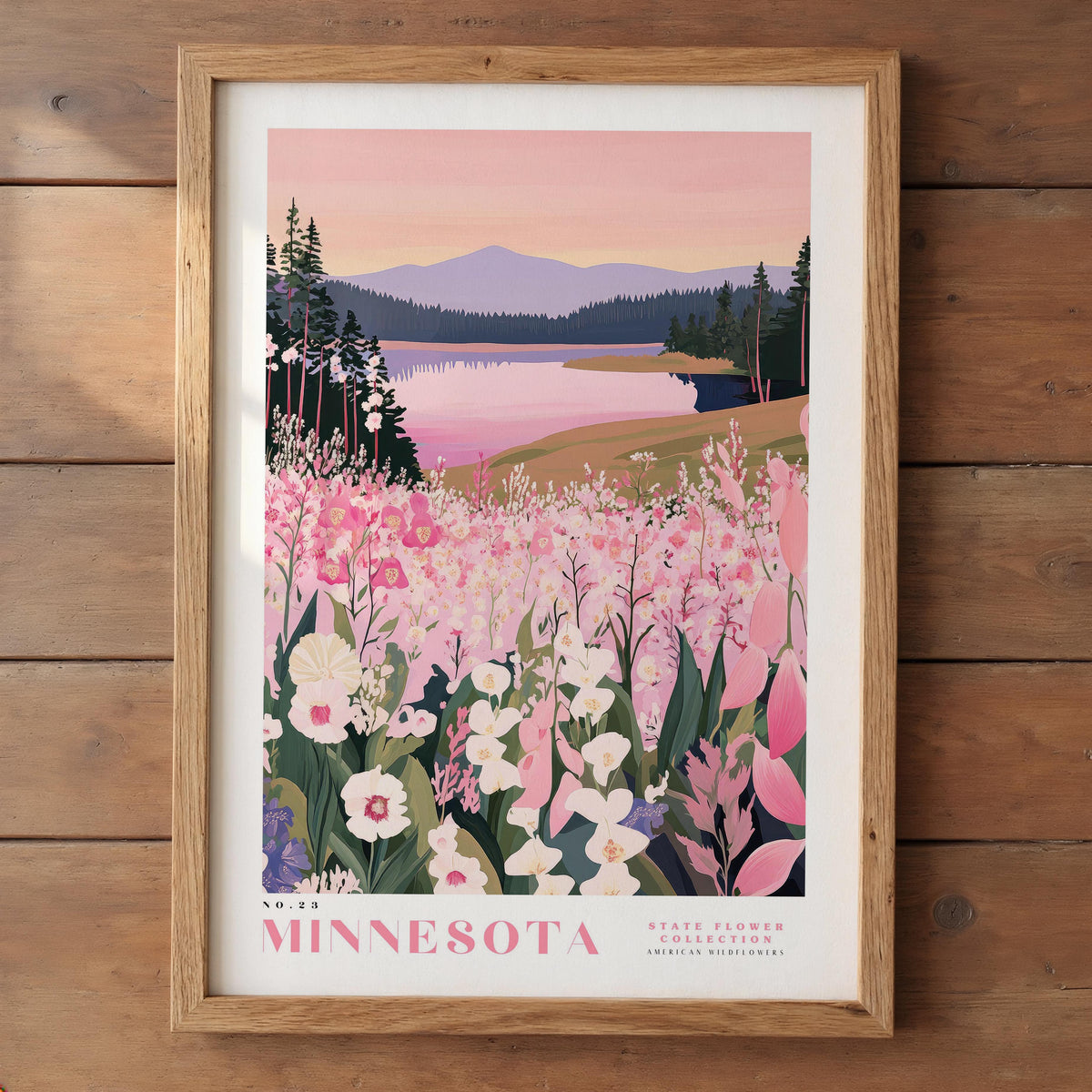 A framed poster depicting a scenic landscape with a lake, mountains, and a field of pink flowers.