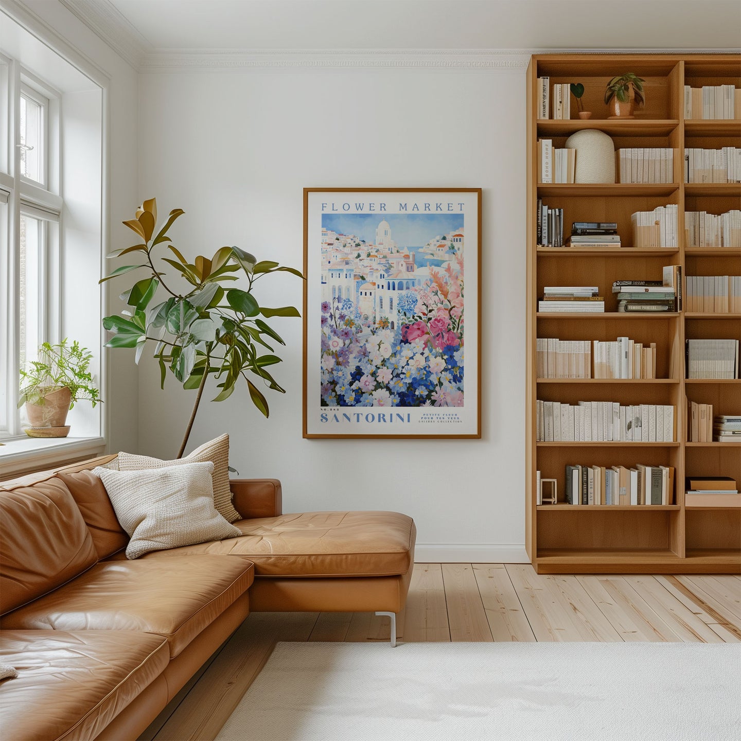 a cozy living room with a large bookshelf filled with books, a comfortable leather couch, and a framed poster of Santorini on the wall.