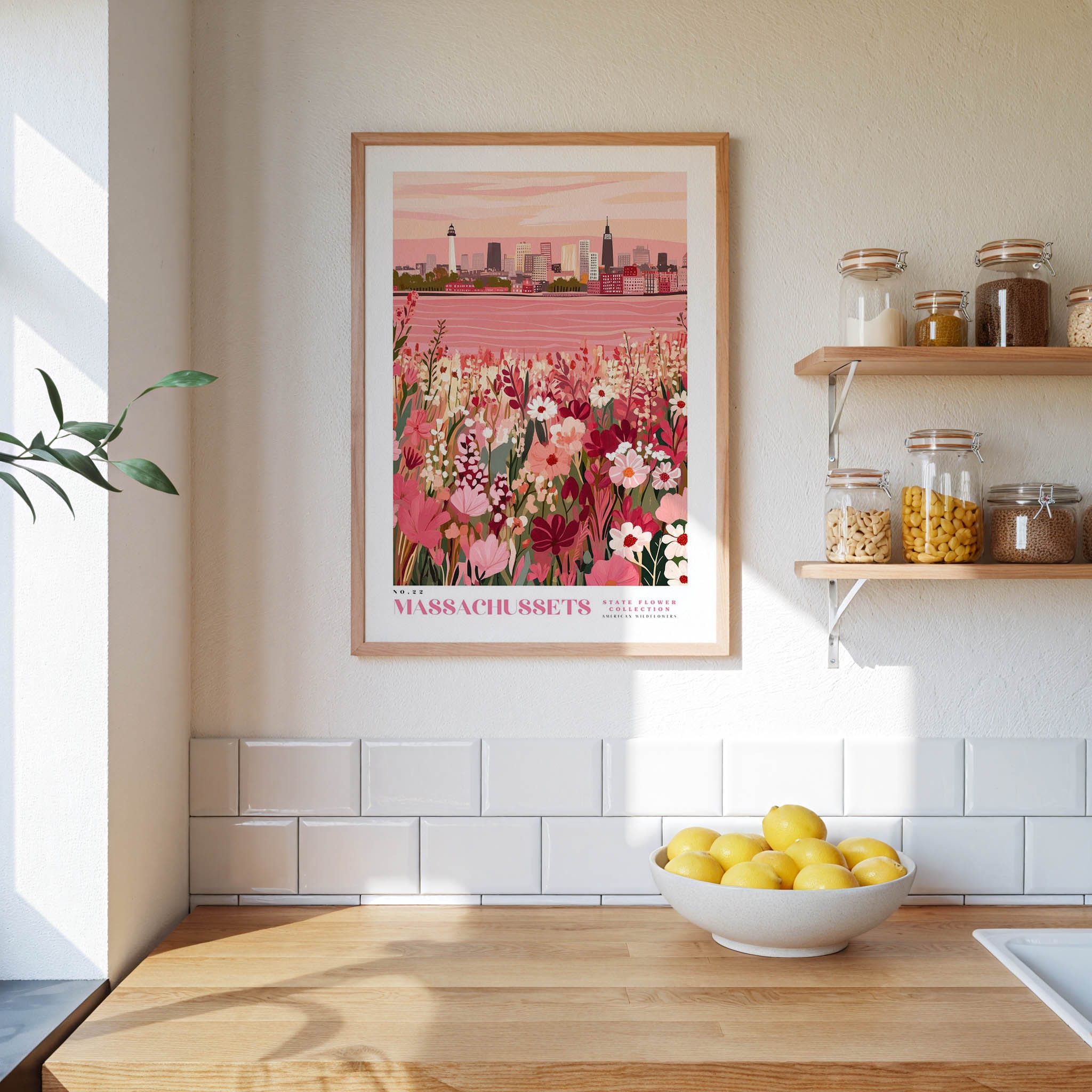 a kitchen scene with a framed poster of a cityscape, a wooden counter with a bowl of lemons, and shelves displaying various jars and containers.