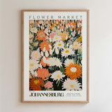 The image is a framed poster of a flower market, featuring a variety of colorful flowers and plants.