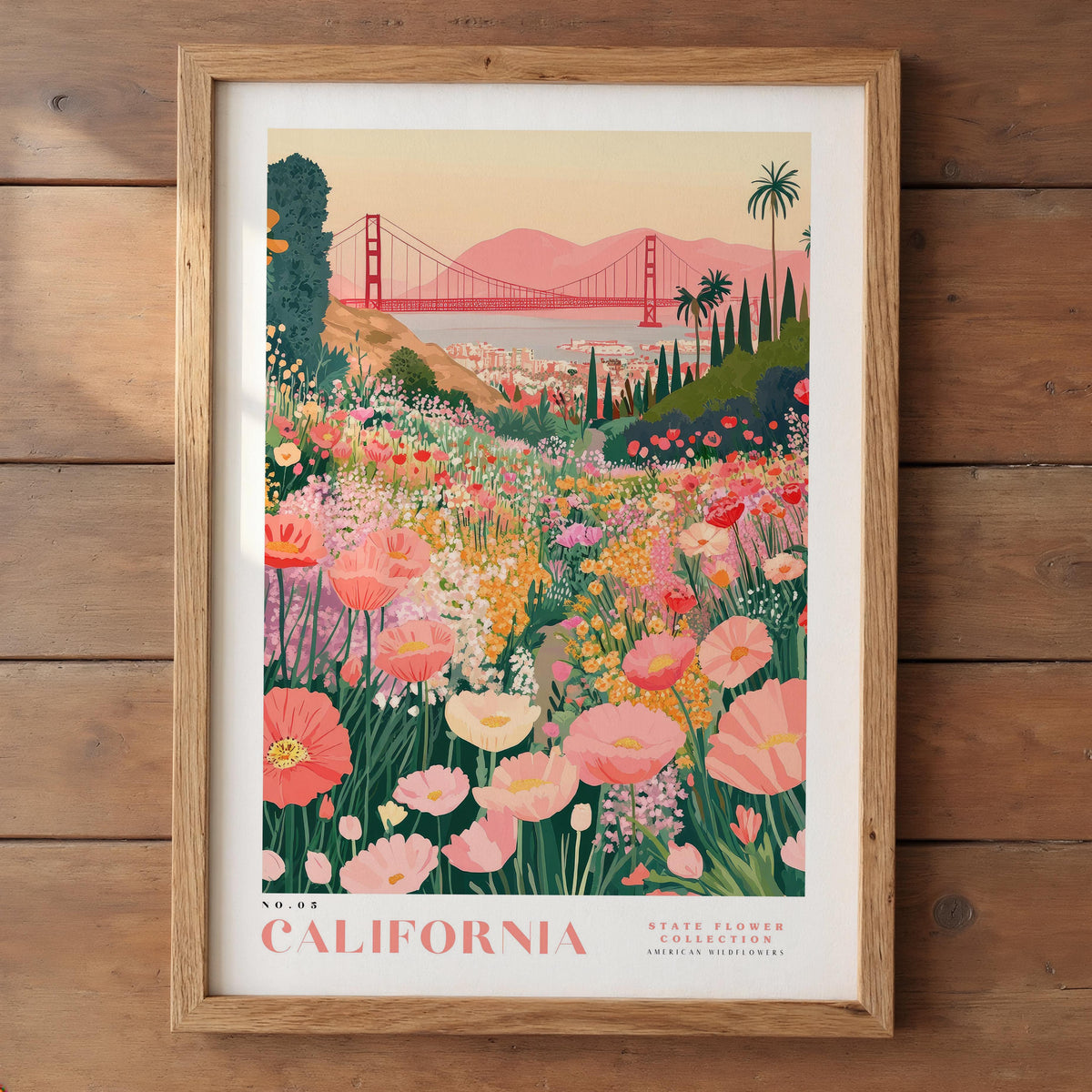 A framed poster depicting a vibrant field of flowers with a red suspension bridge in the background, set against a sunset sky.