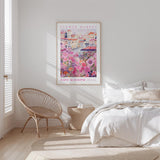 a bedroom with a bed, a woven chair, and a framed poster of a flower market in Saint Augustine, Florida.