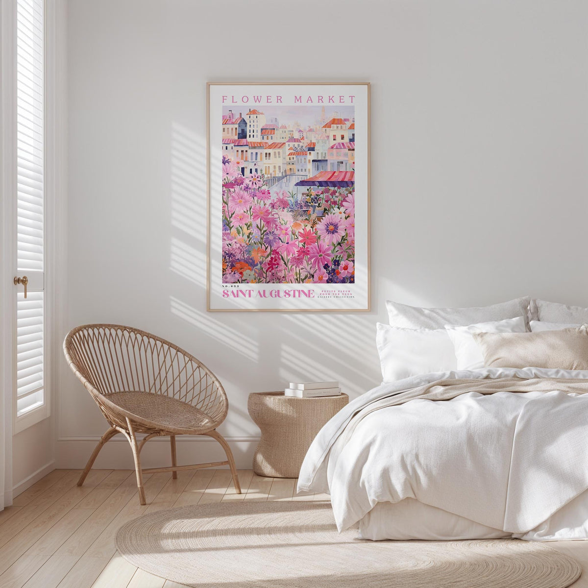 a bedroom with a bed, a woven chair, and a framed poster of a flower market in Saint Augustine, Florida.