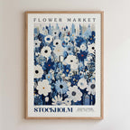 The image is a framed poster depicting a cityscape with a large field of flowers in the foreground.