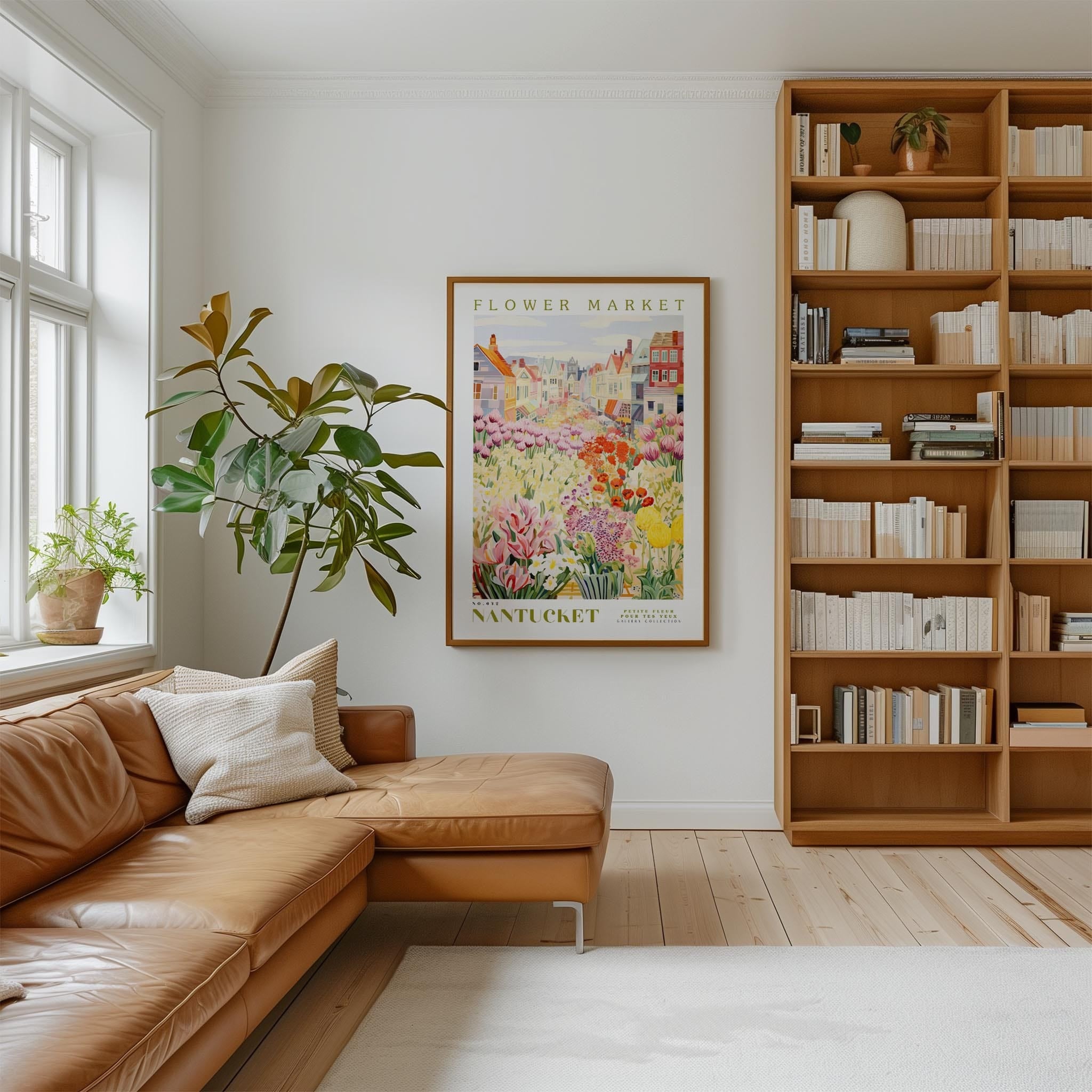 a cozy living room with a large window, a comfortable leather couch, a bookshelf filled with books, and a framed poster of a flower market in the background.