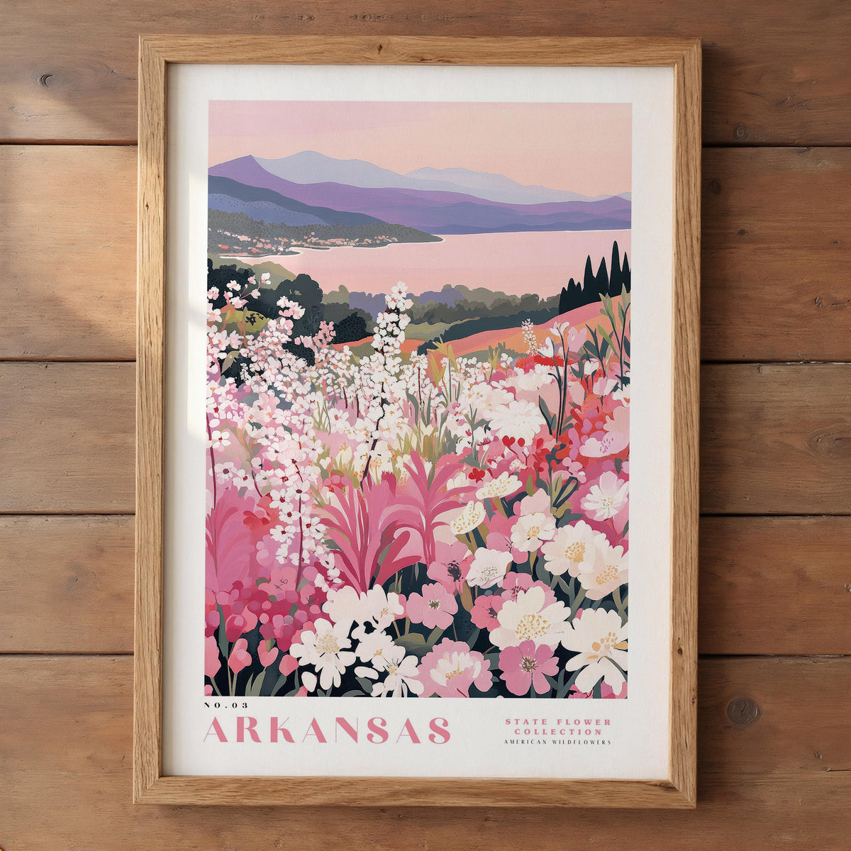 A framed poster depicting a scenic landscape with mountains, a lake, and a field of colorful wildflowers.