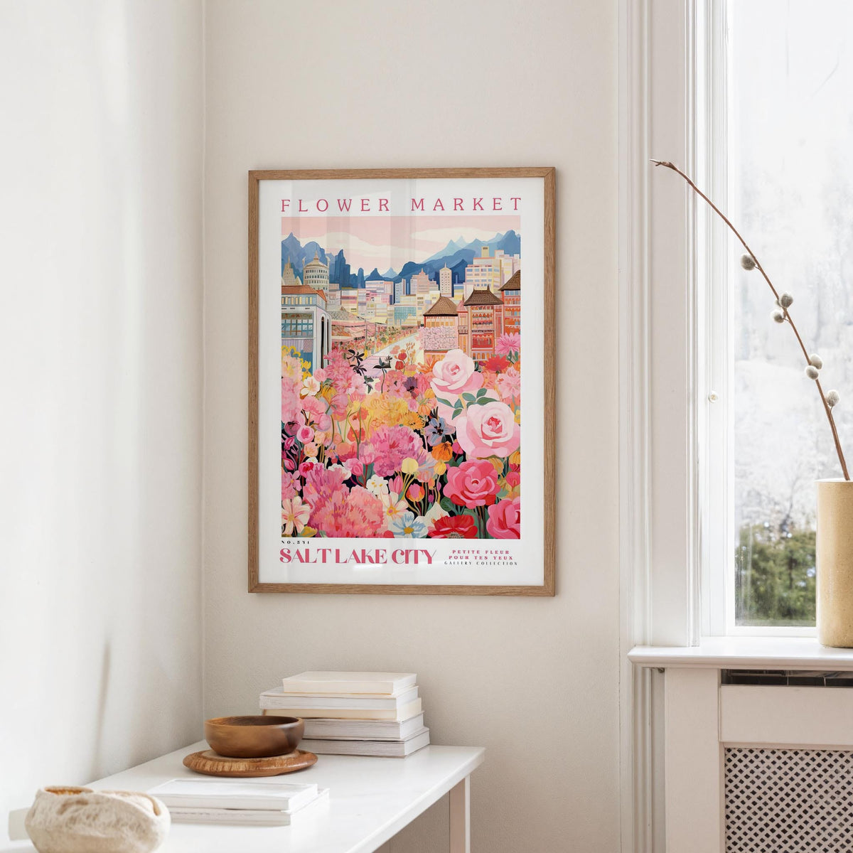 a framed poster of a cityscape with a flower market in the background, hanging on a wall in a room.