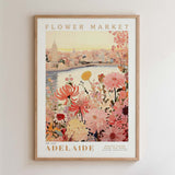 The image is a framed poster depicting a cityscape with a river and a flower market in the background.