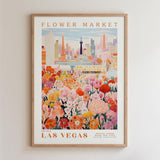 The image is a framed poster depicting a vibrant and colorful scene of a flower market in Las Vegas, with a cityscape in the background.