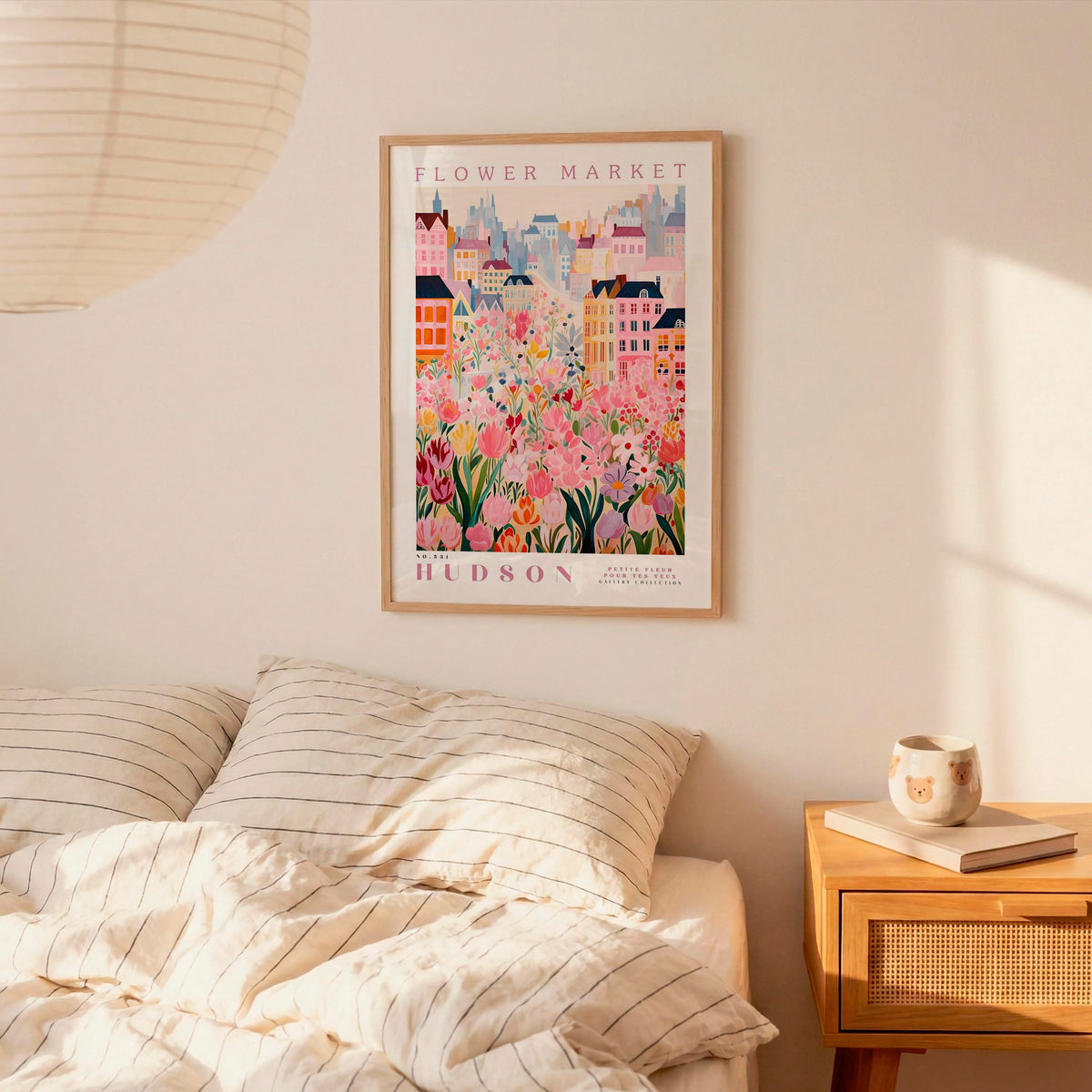 a bedroom setting with a framed poster of a colorful cityscape hanging on the wall above a bed with striped bedding.