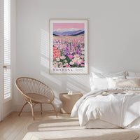 a serene bedroom scene with a large framed poster of a mountain landscape hanging on the wall, a woven chair, and a bed with white bedding.