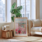 a framed poster of a flower market in Rome, with a potted plant and bookshelf in the foreground.