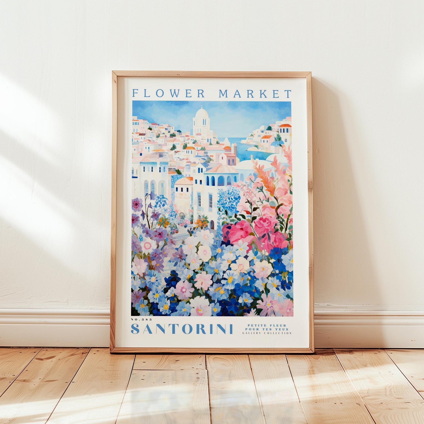 A framed poster of a colorful floral scene, with the text "FLOWER MARKET Santorini" and "Petite Florier Galerie Collection" printed on it.