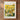 The image is a framed poster depicting a vibrant field of flowers, with a mountainous landscape in the background.