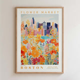 The image is a framed poster depicting a cityscape with a colorful flower garden in the foreground.