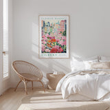 a bedroom with a bed, a wicker chair, and a framed poster of a flower market on the wall.