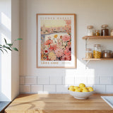 a framed poster of a flower market in Adelaide, Australia, hanging on a wall above a wooden counter with a bowl of lemons.