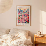 a bedroom scene with a framed poster of a cityscape and a bed with striped bedding.