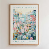 The image is a framed poster depicting a vibrant and colorful flower market scene with various flowers and plants.