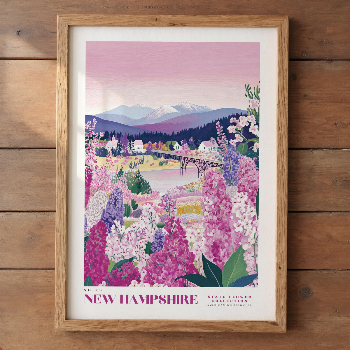 The image is a framed poster depicting a scenic landscape in New Hampshire, featuring a mountain range, a river, and a field of colorful wildflowers.