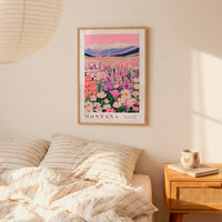 a bedroom scene with a framed poster of a colorful field of flowers hanging on the wall above a bed with striped pillows.