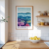 a kitchen counter with a bowl of lemons, a framed poster of a coral reef, and a shelf with jars and bottles.