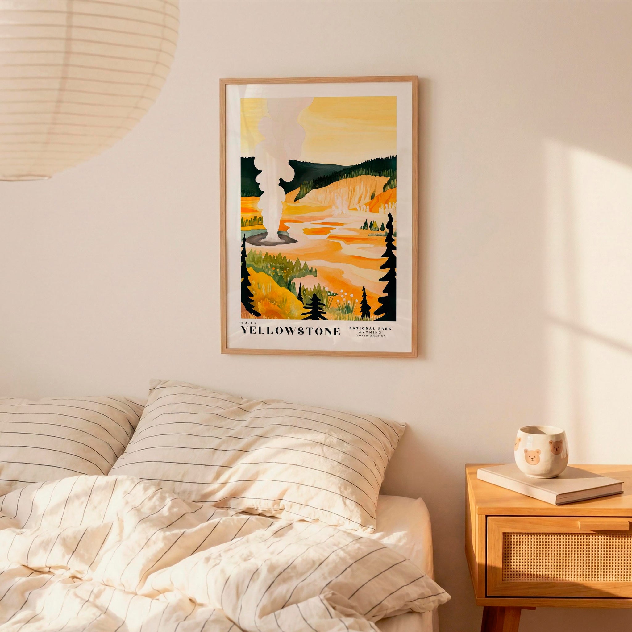 a bedroom scene with a framed poster of a scenic landscape hanging on the wall above a bed with striped bedding.