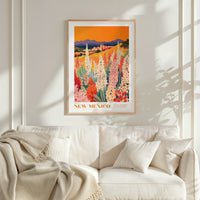 a framed poster of a colorful field of flowers hanging on a wall above a white couch with a blanket draped over it.
