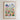The image is a framed poster depicting a colorful cityscape with a variety of flowers and plants in the foreground.