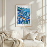 a framed poster of a coastal landscape with a lighthouse, hanging on a wall above a white couch with a blanket draped over it.