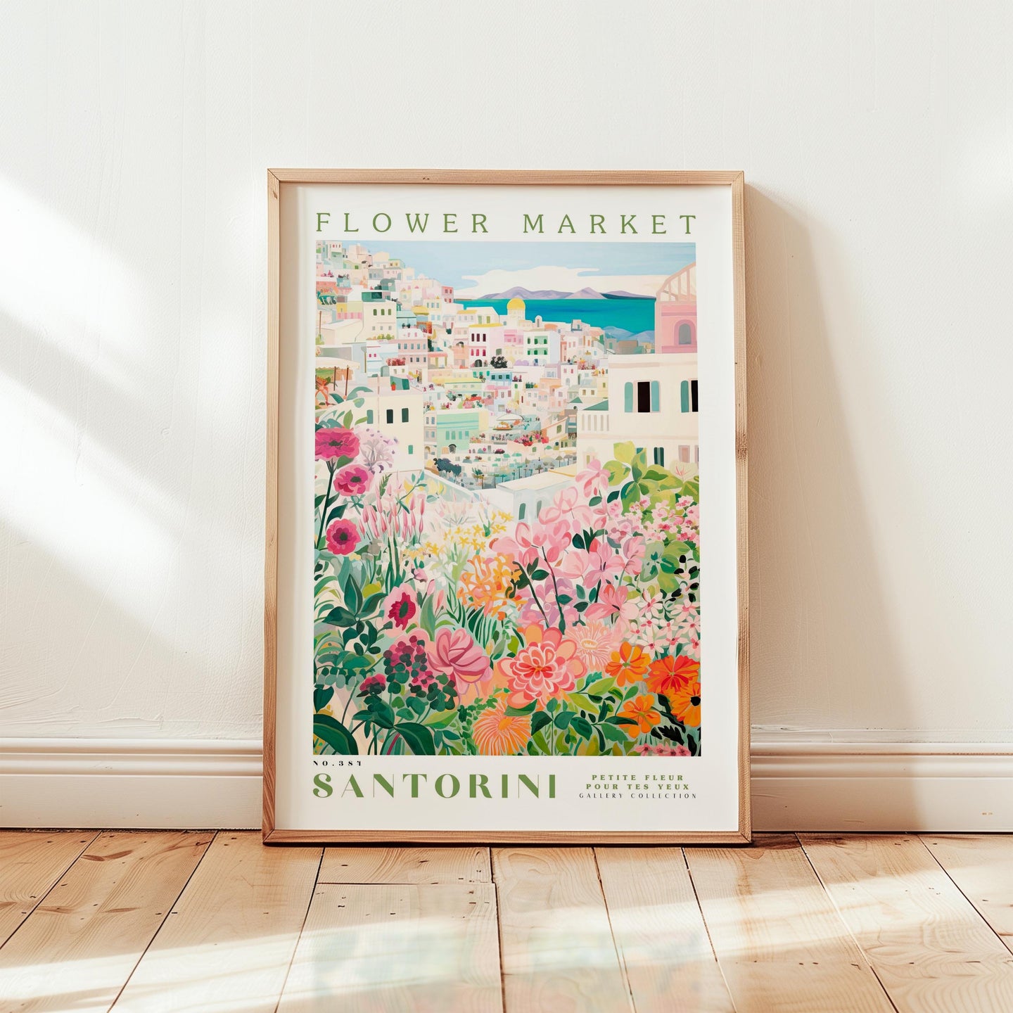 The image is a framed poster of a colorful, floral-themed cityscape, with the text "FLOWER MARKET Santorini Petite Fleur GALLERIE COLLECTIONS" prominently displayed.