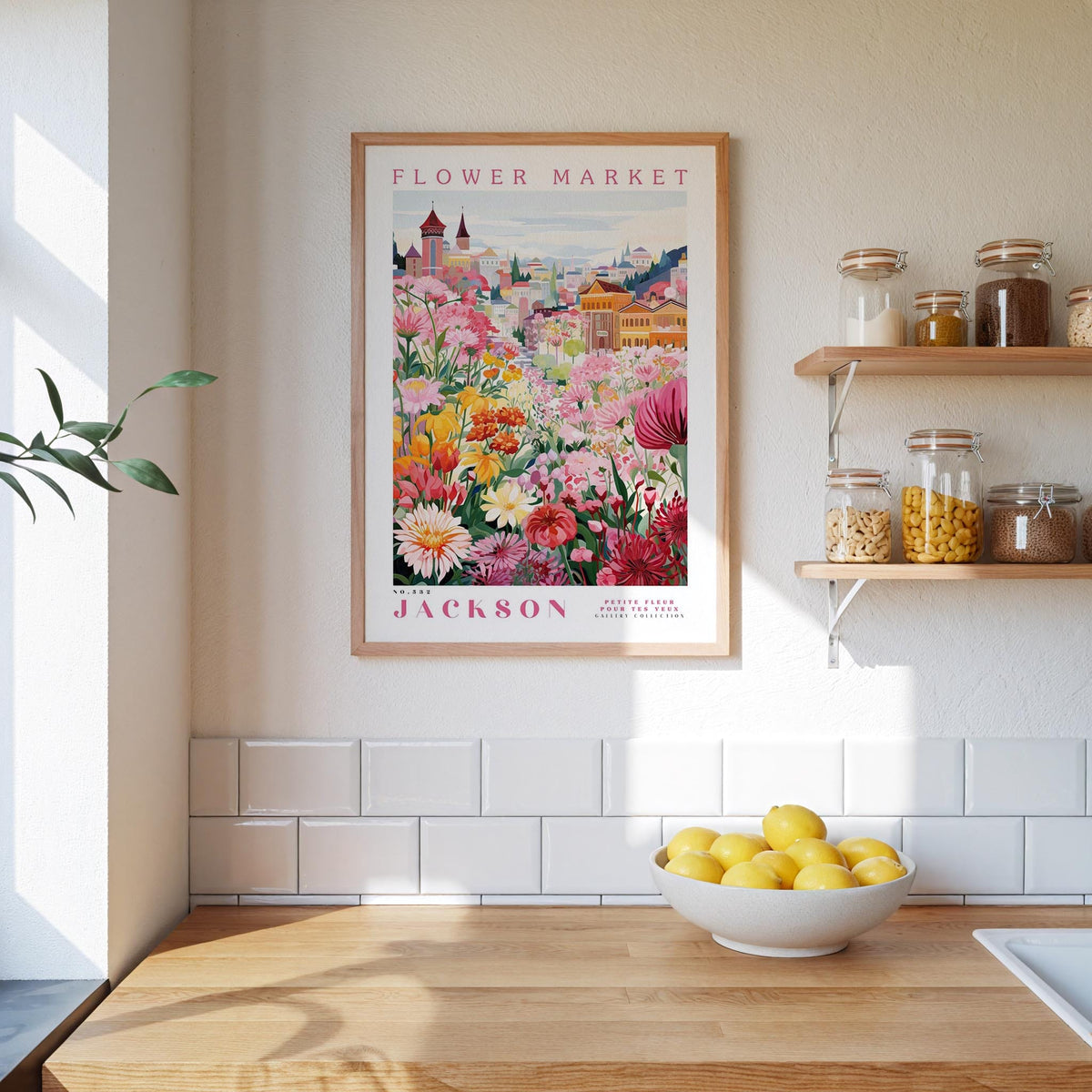 a kitchen counter with a bowl of lemons, a framed poster of a colorful flower market, and a shelf with jars and containers.